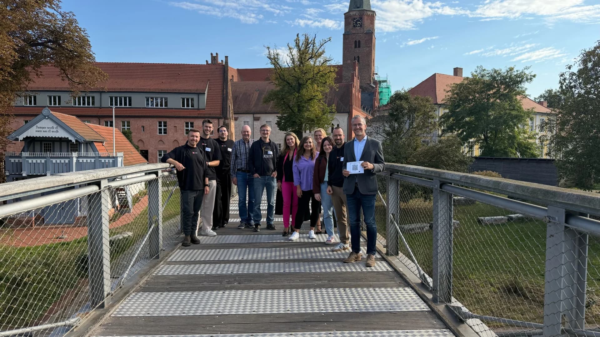 Gruppenfoto der Workshop-Teilnehmenden auf einer Brücke vor dem Brandenburger Dom