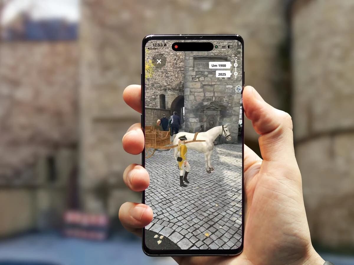 Zeitreise per Smartphone in Goslar: Die AR-Ansicht zeigt am historischen Stadttor die Szenerie um 1900 mit Pferd und Fuhrwerk — per Schieberegler wechselbar zur Ansicht von heute