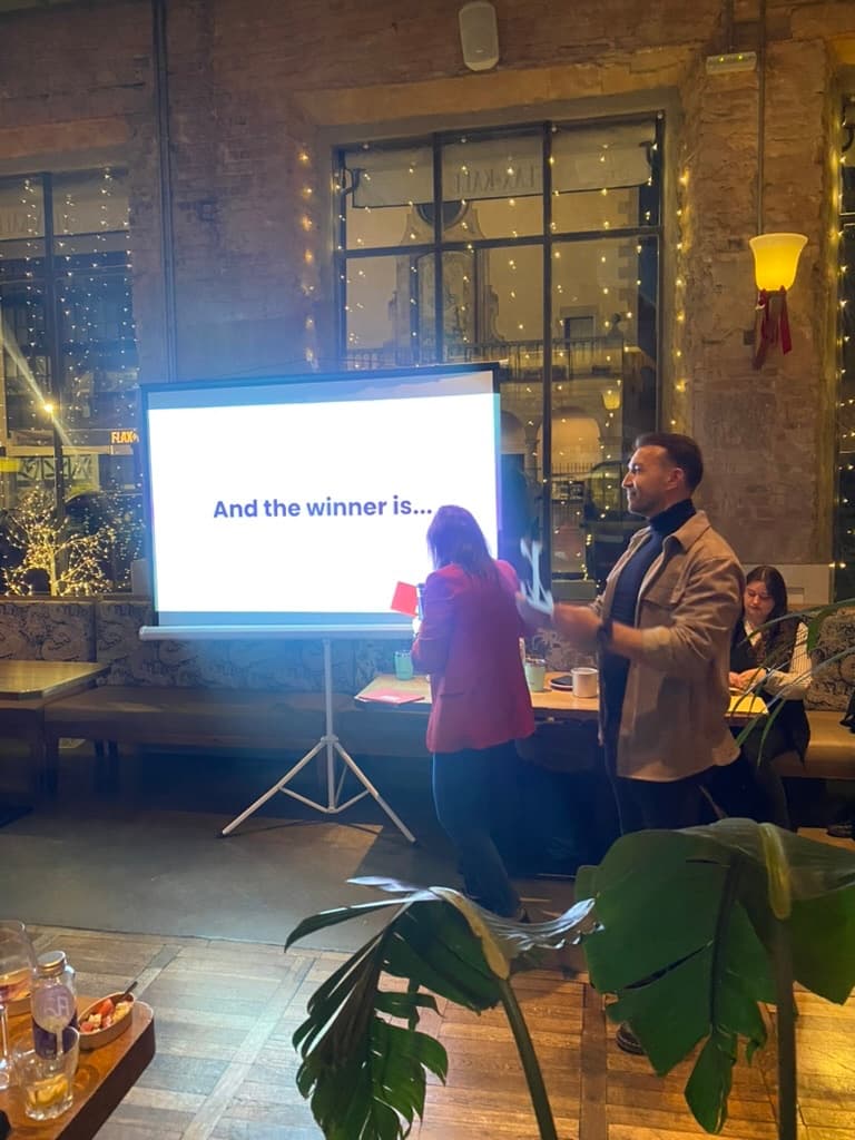 Siegerehrung beim X.Award 2025 im Talent Garden Barcelona: Viktor Waal von spotAR vor der Leinwand mit der Aufschrift 'And the winner is...'